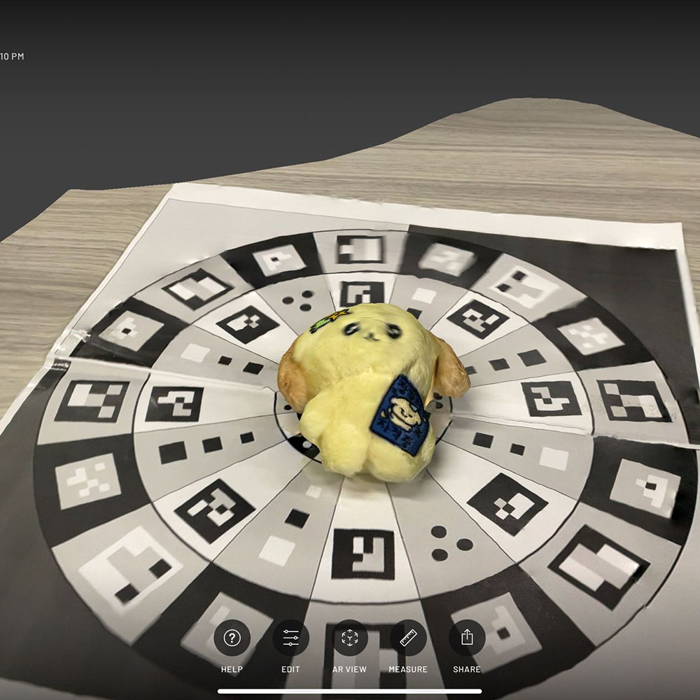 <b>Starting My 3D Scan</b><br>In this photo, I've placed a small toy on a special sheet filled with black and white markers to begin creating a 3D model using the ScanViewer app.