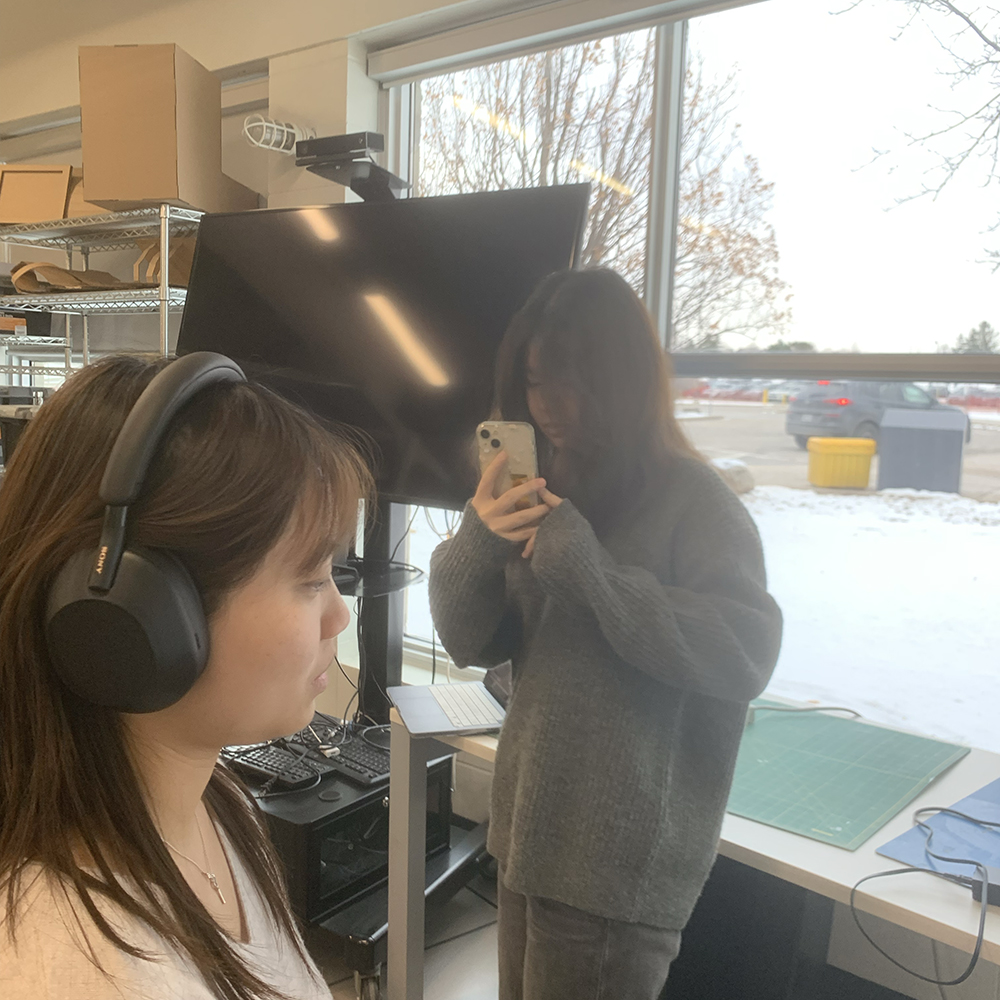 <b>Finalizing the Scan</b><br>Finally, my classmate completes the scanning process. She uses her phone to capture the last details needed for the 3D scan while I still wear the headphones, sitting quietly to ensure we get a good scan.