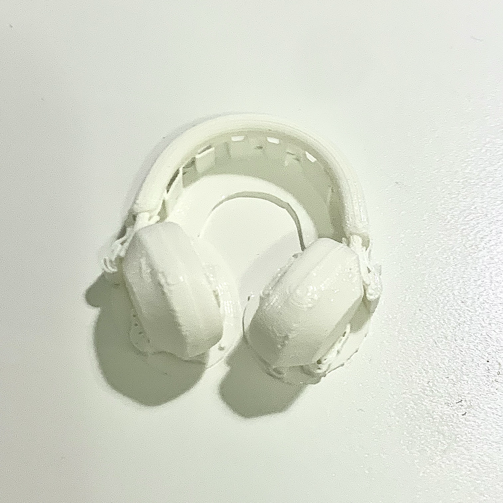 <b>My 3D Printed Headphones Model</b><br>Here are my 3D printed headphones. I used supports to help with the printing process, especially to stabilize the delicate parts like the headband and ear cups. After printing, I plan to sand down the supports to achieve a clean and refined finish on the model.