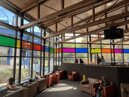 <b>Colorful Lounge with Natural Light</b><br>I captured this lounge area on campus using my phone. Originally designed as a relaxing and study space, the colorful windows and abundant natural light make it a welcoming spot where students can work or take breaks. It’s still used today for informal study and relaxation.