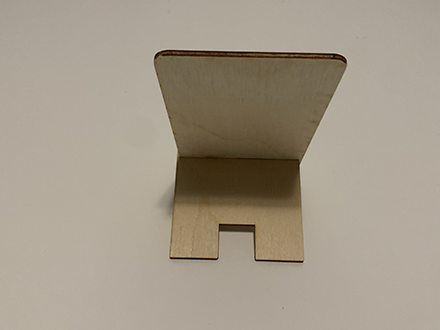 <b>Back View of the Phone Stand</b><br>
          This is the back view of my phone stand, showing the structure and support. The stand has a slot that securely holds the back piece, giving it stability to hold a phone.