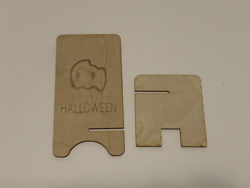 <b>Unassembled Pieces of the Phone Stand</b><br>
          In this image, the phone stand pieces are laid out before assembly. The engraved front piece and the supportive back piece are ready to be slotted together. This design makes it easy to assemble and disassemble when needed.