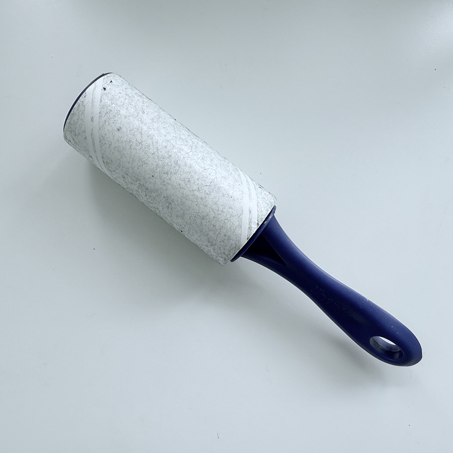 A lint roller with a dirty adhesive sheet, capturing the sound of it picking up lint and debris from fabric.
