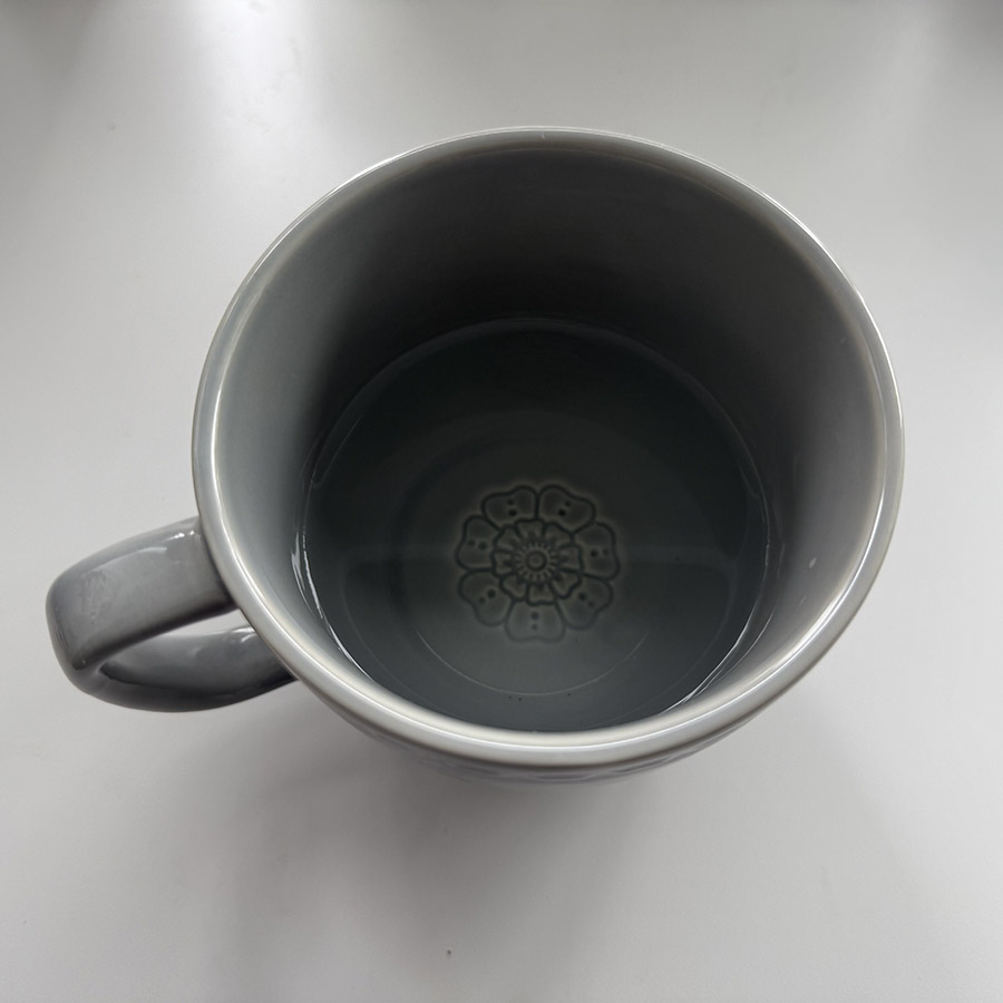 An empty mug positioned to suggest the sound of sipping or drinking water.