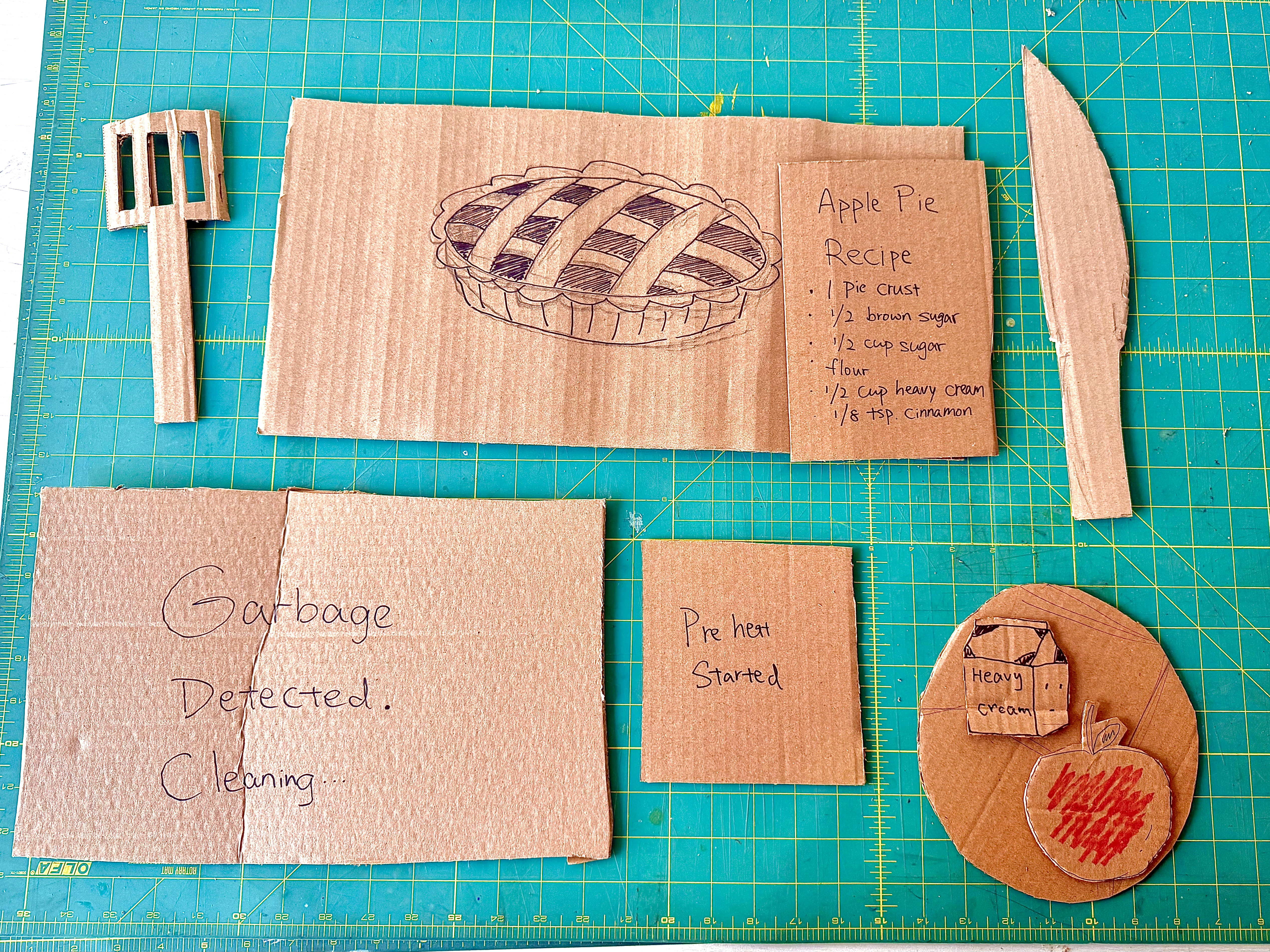 <b>Tools and props</b><br>These are the cardboard tools and props we made for our smart kitchen workshop. We created items like a recipe card, ingredients, and cooking tools to support the apple pie scenario. They helped us act out how the smart kitchen gives instructions to the user.